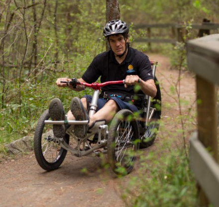 A man using an electric three wheel cycle on a fore